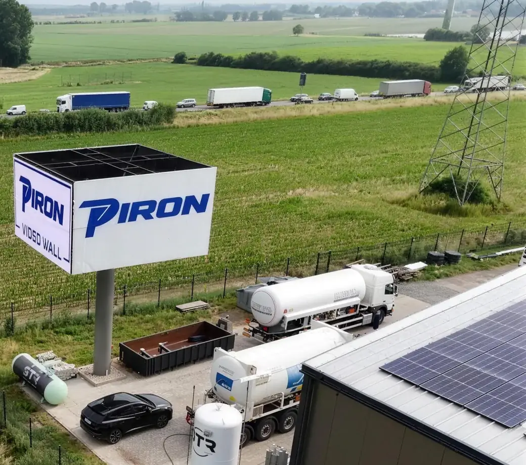 Luftaufnahme: die Piron LED Wall am Feldrand neben der Halle, dahinter dichter Verkehr auf dem Tweestrom